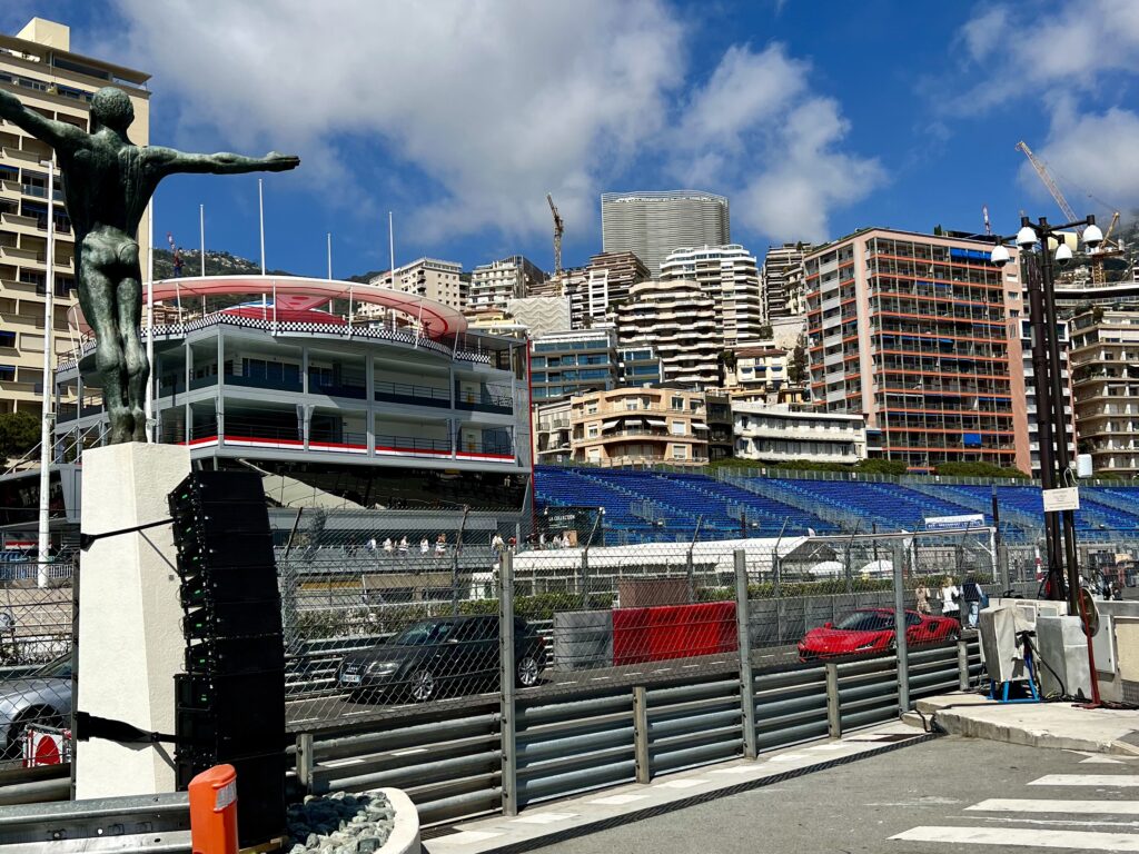 A Lamborghini Driving Through Monaco with F1 Race Prep in the Background